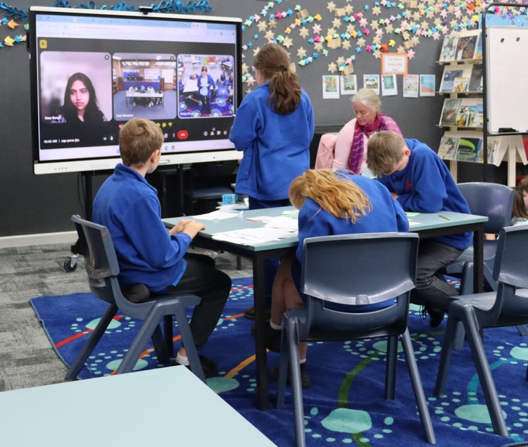 Students participating in a virtual debate supported by a teacher.