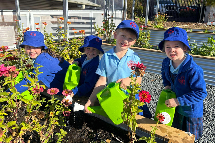 Students watering the flowers in our school garden.