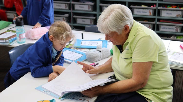 A student and their grandparent at open classrooms sharing learning.
