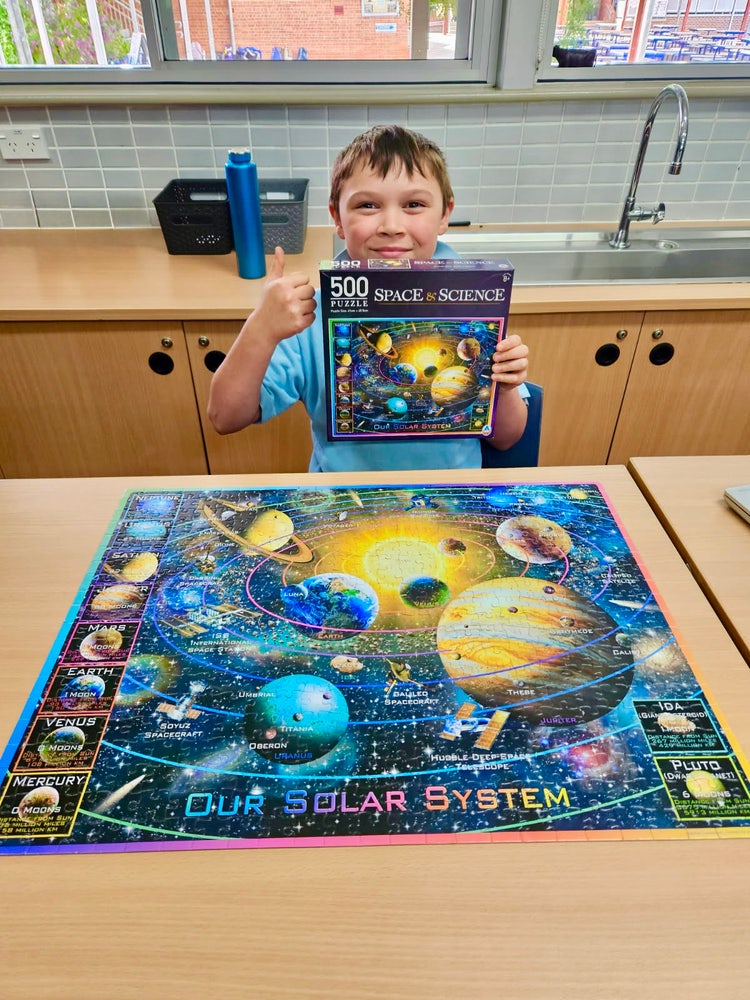 Student with his completed jigsaw puzzle.