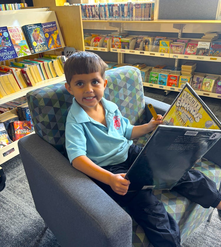 Student reading a book in the school library.