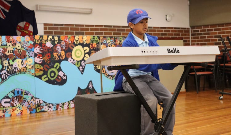 Student engaging in tailored music lessons during concert band rehearsal.