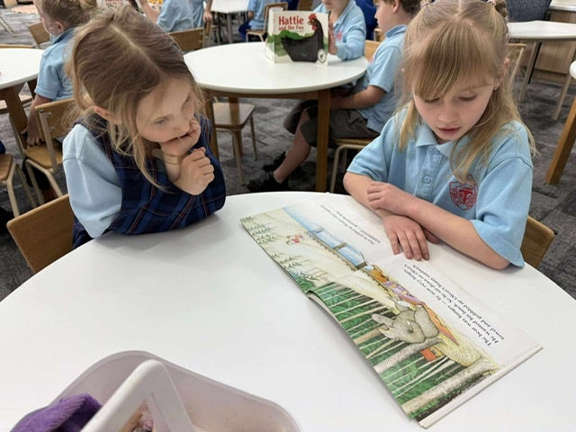 Two children engaging in fluency pairs during reading instruction.